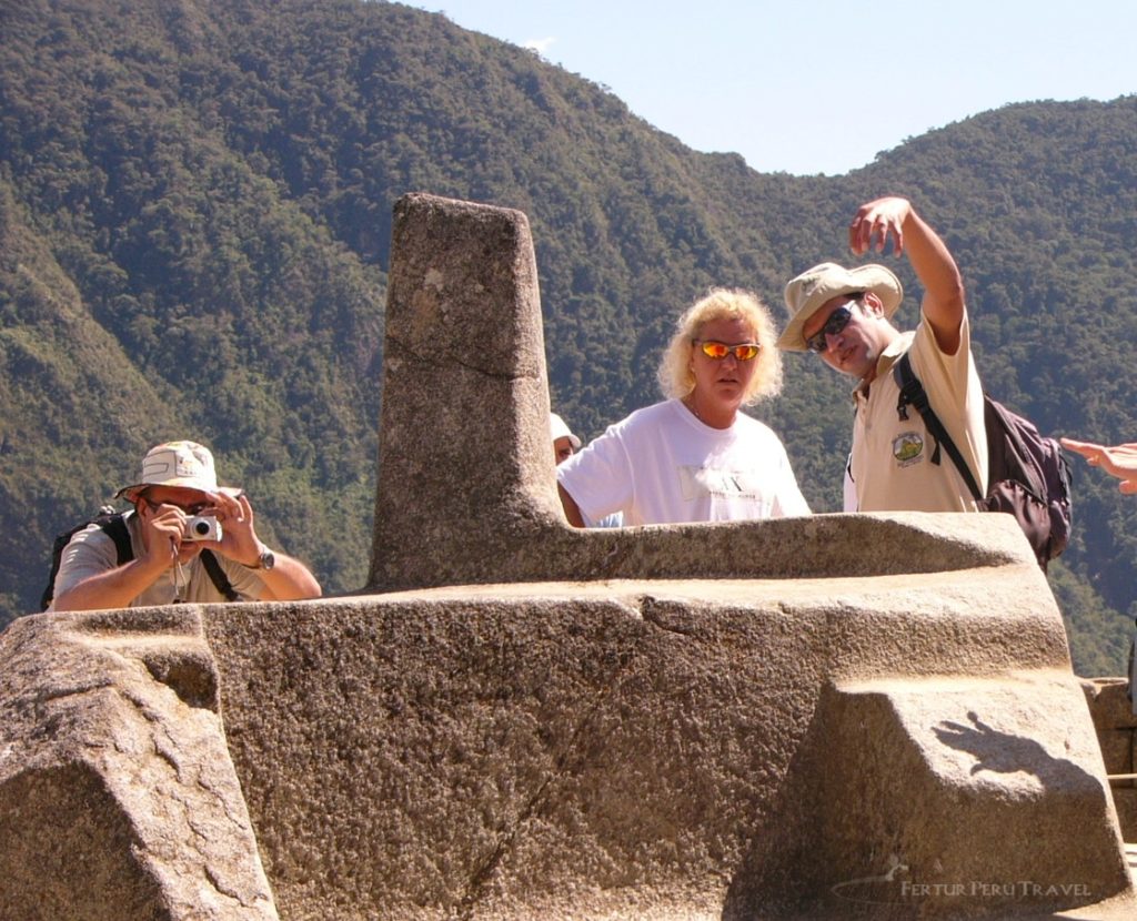 Tourists get close up to the Intihuatana (Hitching Post of the Sun) at Machu Picchu. This Inca shrine is currently off limits to visitors. 