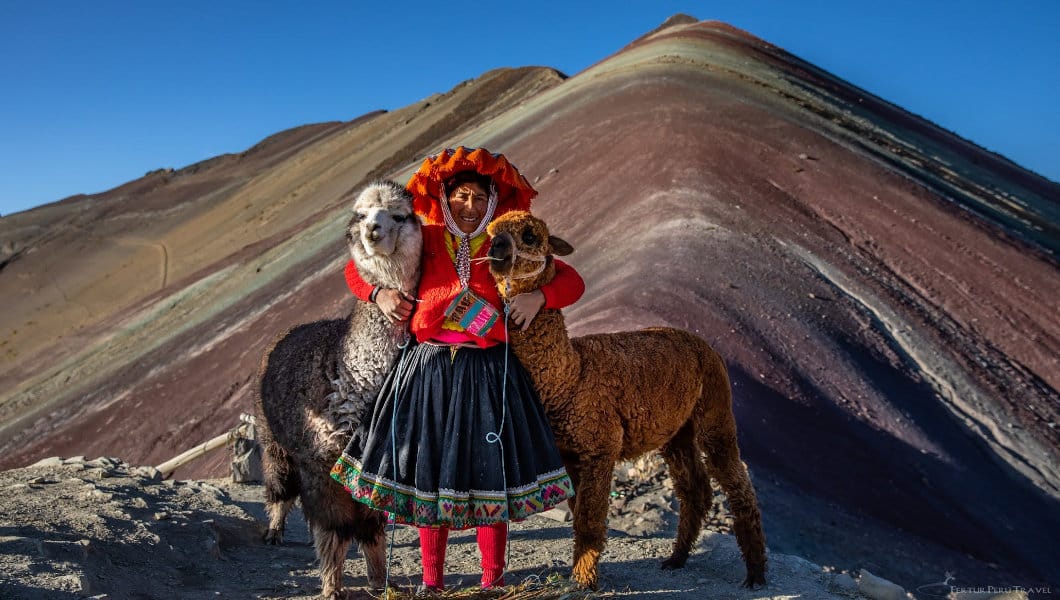 Local woman with her two alpacas at the summit of Rainbow Mountain - Vinicunca, Cusco, Peru